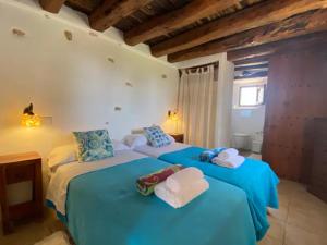 two beds in a room with blue sheets and towels at CAN FARITZEO in Sant Rafael de Sa Creu +106 photos