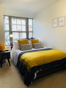 a bedroom with a large bed with a yellow blanket at Boutique Townhouse Uphill Lincoln in Lincolnshire