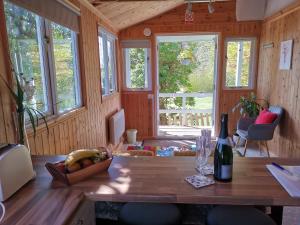 a room with a table and a bottle of wine at Treeside woodhouse in Hawkshead