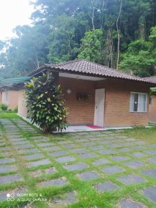 a house with a stone driveway in front of it at Recanto beira rio in Sana