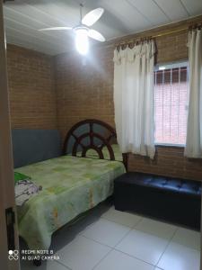 a bedroom with a bed and a window at Recanto beira rio in Sana