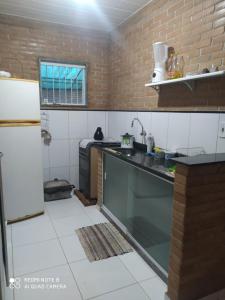 a kitchen with a sink and a refrigerator at Recanto beira rio in Sana