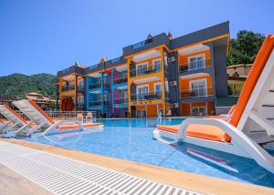 a swimming pool with chairs and a hotel at Speedy Apart Otel in Marmaris