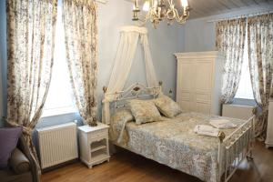 a bedroom with a bed and a chandelier and windows at Nostos Hotel in Galaxidhion