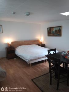 a bedroom with a bed and a desk and a table at La Baronnerie in Saint-Marc-dʼOuilly