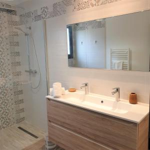 a bathroom with a sink and a shower with a mirror at Villa Leku Lucia 8 pers piscine chauffée 15 min plage en voiture in Sainte-Lucie de Porto-Vecchio