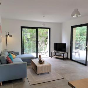 uma sala de estar com um sofá e uma mesa de centro em Villa Leku Lucia 8 pers piscine chauffée 15 min plage en voiture em Sainte-Lucie de Porto-Vecchio