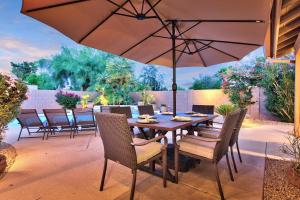 een tafel en stoelen met een parasol op een terras bij Sunset Ridge in Phoenix