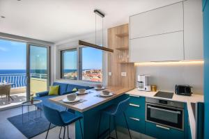 a kitchen with blue cabinets and a view of the ocean at Villa Leoni in Dubrovnik