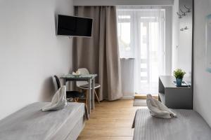 a bedroom with two beds and a desk and a television at Marinas Rewa in Rewa