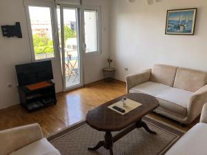 a living room with a couch and a coffee table at Square apartment Podgorica in Podgorica