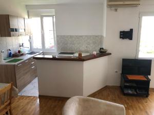 a kitchen with a counter in the middle of a room at Square apartment Podgorica in Podgorica