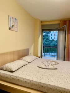 - une chambre avec un grand lit et une fenêtre dans l'établissement Arti apartment, à Vlorë