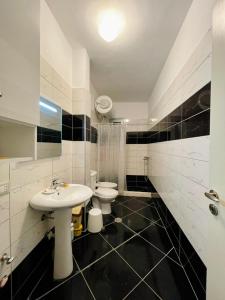 La salle de bains blanche est pourvue d'un lavabo et de toilettes. dans l'établissement Arti apartment, à Vlorë