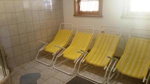 three yellow chairs sitting in a room with a bathroom at Appartements Kirchgasser Radstadt in Radstadt