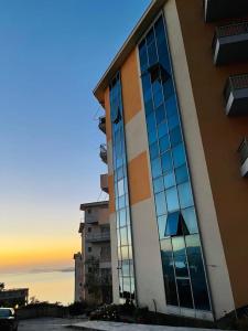 un bâtiment doté de fenêtres en verre sur son côté dans l'établissement Arti apartment, à Vlorë