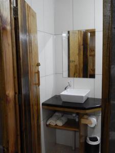a bathroom with a sink and a mirror at Pousada Rural Paiol dos Pellizzaro in Concordia