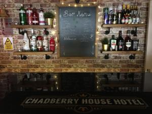 a bar with a chalkboard and bottles of alcohol at Chadberry House Hotel in Blackpool +44 photos