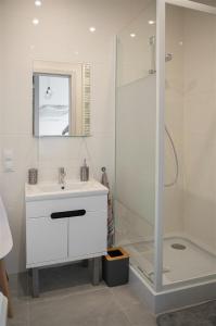 un baño con lavabo y ducha en APARTAMENTwPUCKu, en Puck