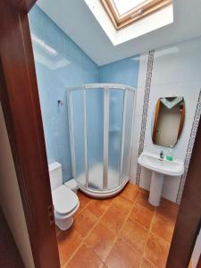ein Bad mit einer Dusche, einem WC und einem Waschbecken in der Unterkunft Piso Don Ramón in Razo