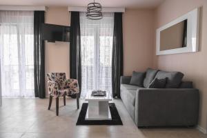 ein Wohnzimmer mit einem Sofa und einem Stuhl in der Unterkunft Apartmani MiS in Šabac