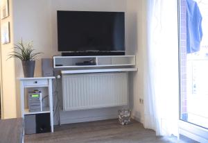 een woonkamer met een flatscreen-tv aan de muur bij Zur Hanse Wohnung 1 4 in Zingst