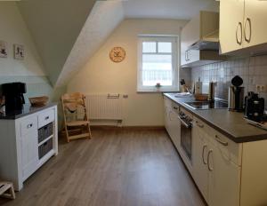 青斯特的住宿－Zur Hanse Wohnung 4 5 - Zur Hanse West，一间厨房,配有白色的橱柜和大窗户