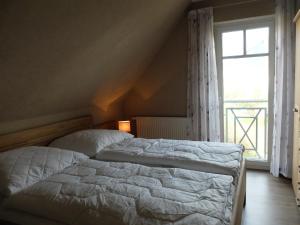 een slaapkamer met 2 bedden en een groot raam bij Zur Hanse Wohnung 4 5 - Zur Hanse West in Zingst