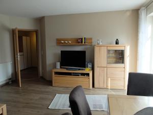 青斯特的住宿－Zur Hanse Wohnung 4 5 - Zur Hanse West，客厅配有木柜上的电视