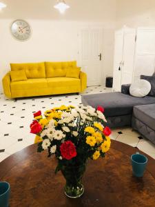 una sala de estar con un jarrón de flores sobre una mesa en Villa Baltica Stegna, en Stegna