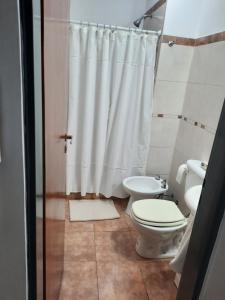 uma casa de banho com um WC e uma cortina de chuveiro em Monoambiente Plaza San Miguel em Paraná