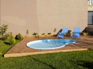 a hot tub in the middle of a yard with two chairs at Casa O Rueiro in Esteiro