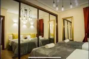 - une chambre avec 2 lits et un grand miroir dans l'établissement Centro Monumental Parking opcional Aire acondicionado, à Salamanque