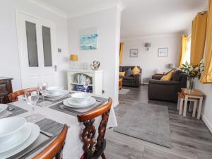 a dining room and living room with a table and chairs at Little Orme Bungalow in Llandudno