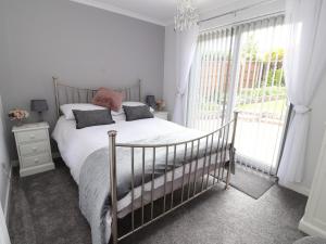a bedroom with a bed and a large window at Little Orme Bungalow in Llandudno