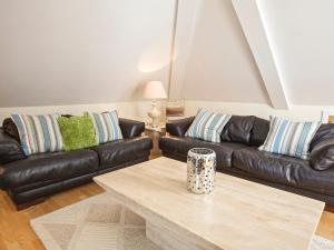 a living room with two leather couches and a coffee table at Ocean View Apartment in Thurlestone