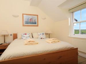 a bedroom with a bed with two towels on it at Ocean View Apartment in Thurlestone