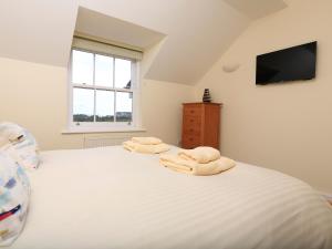 a bedroom with a white bed with towels on it at Ocean View Apartment in Thurlestone