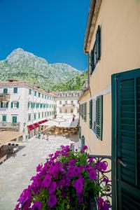 a view from a balcony of a town with purple flowers at Apartments Hun in Kotor