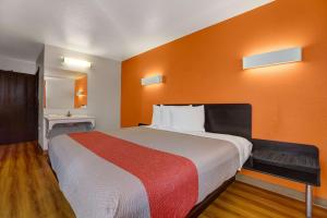 a bedroom with a large bed with an orange wall at Motel 6-Truth Or Consequences, NM in Truth or Consequences