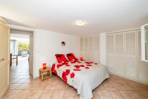 a white bedroom with a large bed with red pillows at Maison d'une chambre avec jardin clos et wifi a Arles sur Tech in Arles-sur-Tech