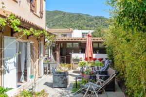 patio con sedie, ombrellone e tavolo di Maison charmante à Arles sur Tech avec vue sur la montagne ad Arles-sur-Tech