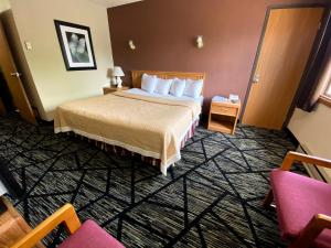 Postel nebo postele na pokoji v ubytování Woodland Inn & Suites