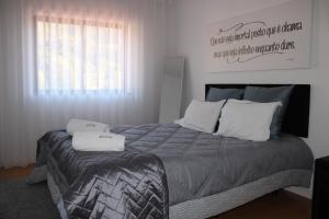 a bedroom with a large bed with two pillows at Casa Sandra - Apartamento Mariana in Lousã