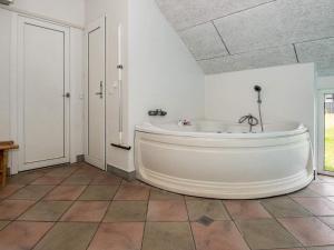 baño con bañera blanca grande y suelo de baldosa. en 12 person holiday home in Glesborg, en Fjellerup Strand