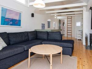 a living room with a blue couch and a table at 12 person holiday home in Glesborg in Fjellerup Strand