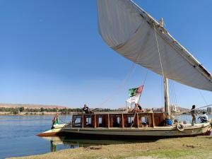 Una barca sull'acqua con delle persone sopra. di JJ Jamaica Felucca a Aswan