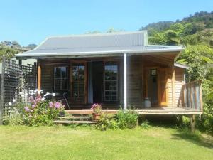 a small wooden house with a porch at The Innlet, Country Apartments and Cottages in Collingwood