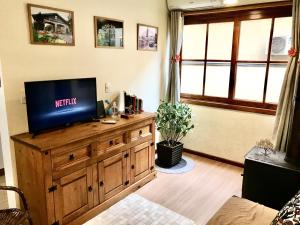 a living room with a television on a wooden dresser at Refúgio na Serra, um espaço para ser desfrutado! in Gramado