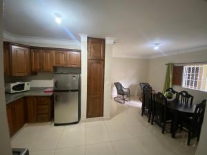 a kitchen with a refrigerator and a table with chairs at Oasis de paz in Jarabacoa